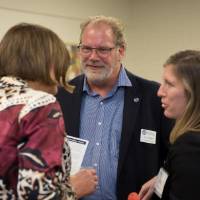 Faculty members and alumni speaking and smiling